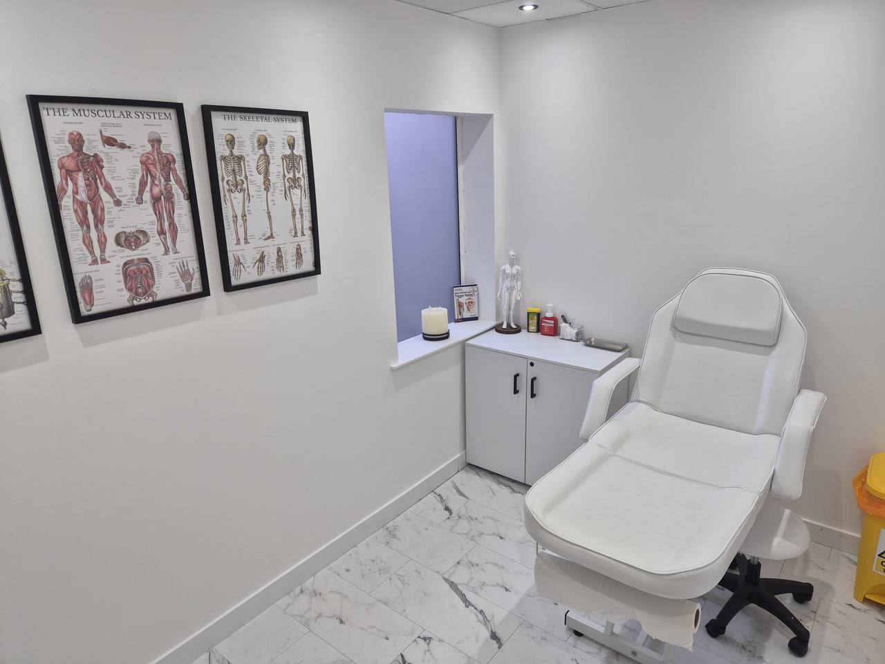 MAW Clinic treatment room with anatomical posters and clinical treatment chair