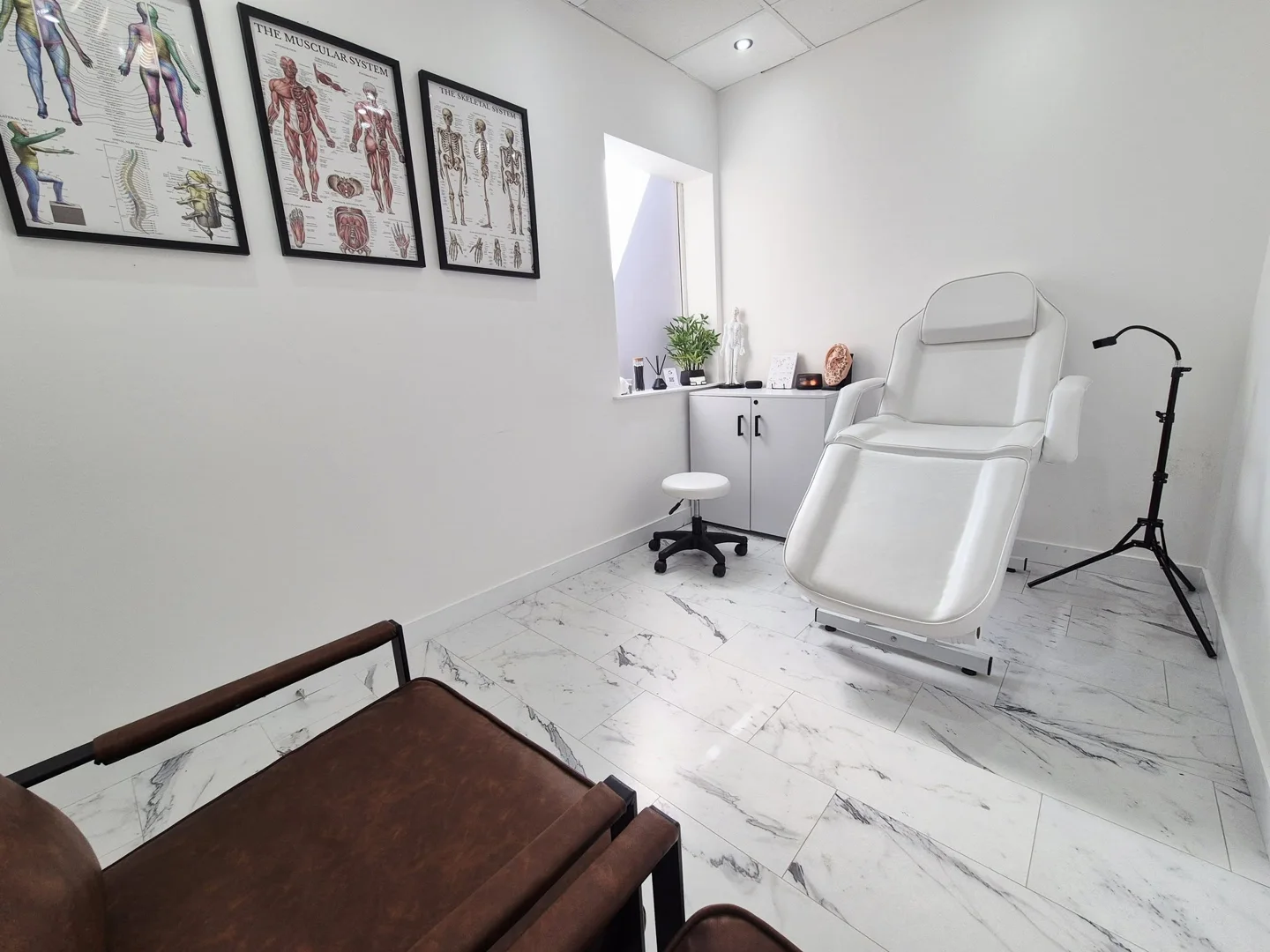 MAW Clinic’s real treatment room with treatment chair and anatomy charts