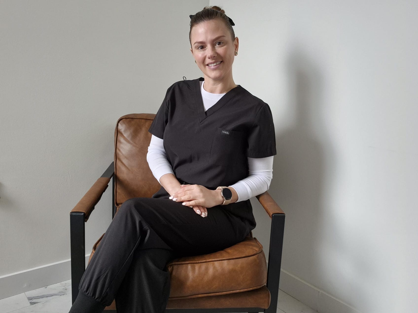Maxine, Registered Nurse and Medical Acupuncturist, seated in clinic uniform