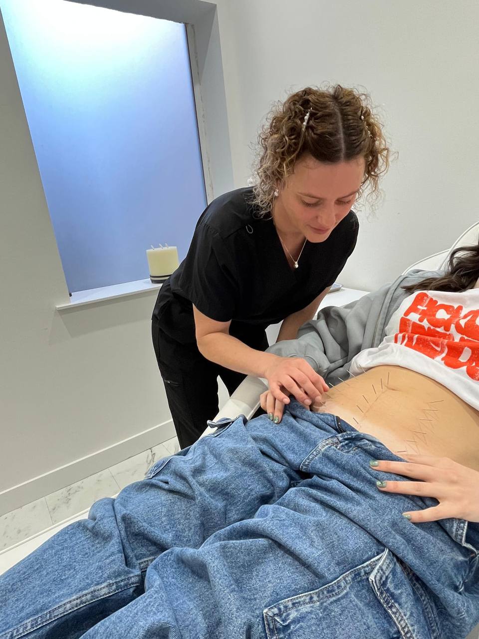 Maxine carrying out acupuncture treatment in the clinic